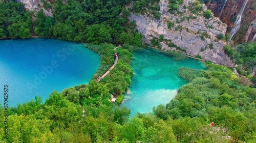 The National Park of Plivice Lakes in mountain Krast in Croatia. The aerial view of board walk on waterfall cascade of Plitvice Lakes  the UNESCO World Heritage. Travel destination for turists.