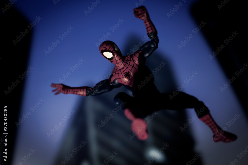 Naklejka premium NEW YORK USA - AUGUST 9 2020: Marvel comics superhero Spiderman swinging from a web at night - Hasbro action figure