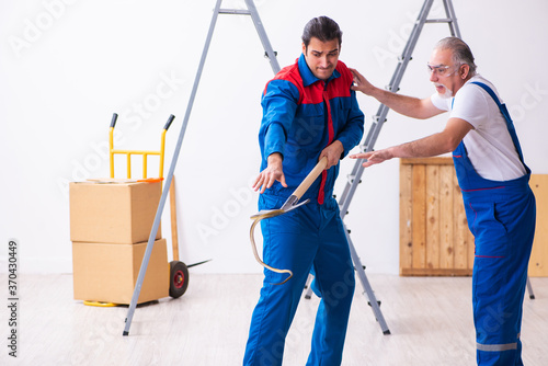 Two contractors and snake indoors