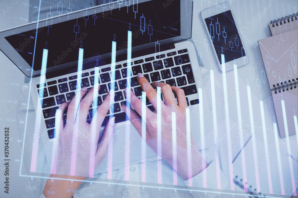 Double exposure of woman hands working on computer and forex chart hologram drawing. Top View. Financial analysis concept.