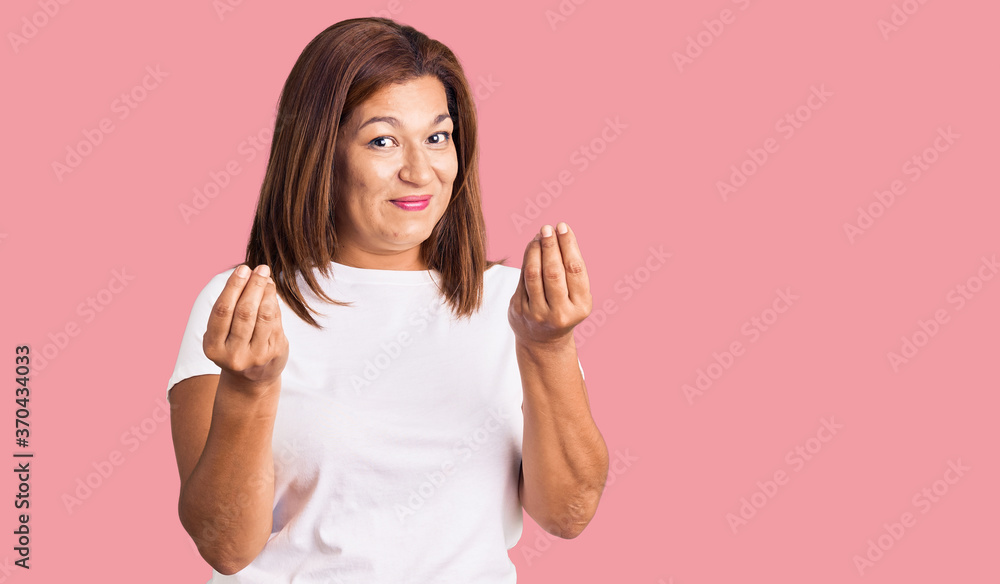 Middle age latin woman wearing casual white tshirt doing money gesture with hands, asking for salary payment, millionaire business Middle age latin woman wearing casual white tshirt doing money gesture with hands, asking for salary payment, millionaire business