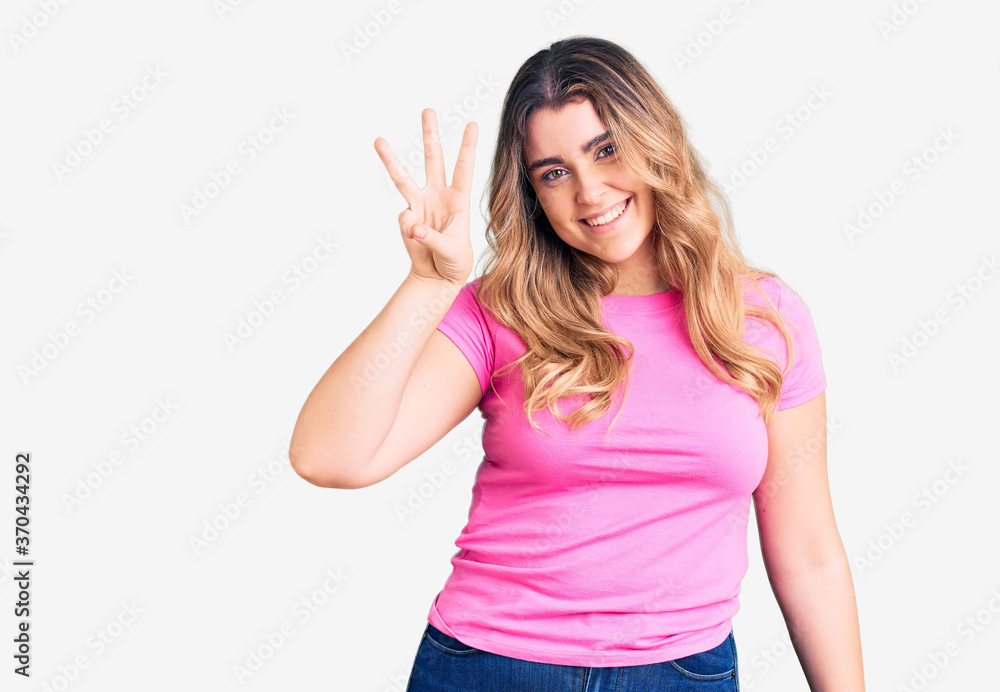Young caucasian woman wearing sportswear showing and pointing up with fingers number three while smiling confident and happy. Young caucasian woman wearing sportswear showing and pointing up with fingers number three while smiling confident and happy.