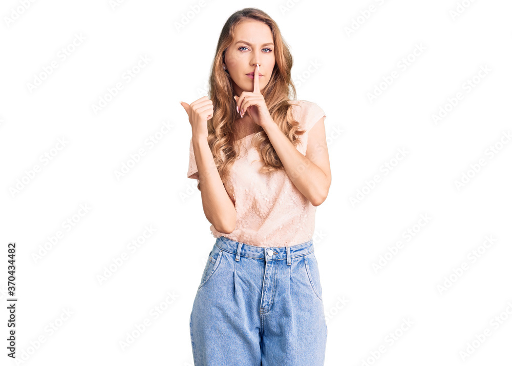 Fototapeta premium Young beautiful caucasian woman with blond hair wearing casual clothes asking to be quiet with finger on lips pointing with hand to the side. silence and secret concept.