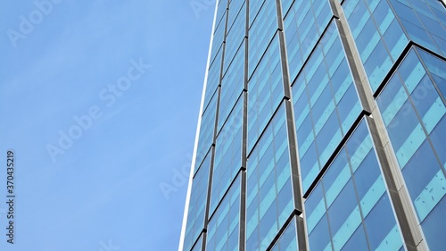 Bottom view of glass silhouette of skyscraper. Business building. Skyscraper with glass facade. Modern building in business district. Concepts of economics, financial, future. 