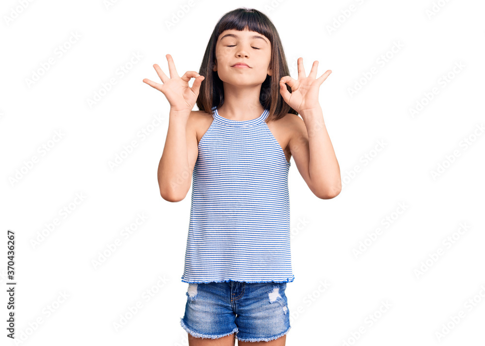 Young little girl with bang wearing casual clothes relax and smiling with eyes closed doing meditation gesture with fingers. yoga concept. Young little girl with bang wearing casual clothes relax and smiling with eyes closed doing meditation gesture with fingers. yoga concept.