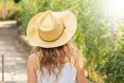 Obraz na plátne woman in hat in summer outdoors from behind