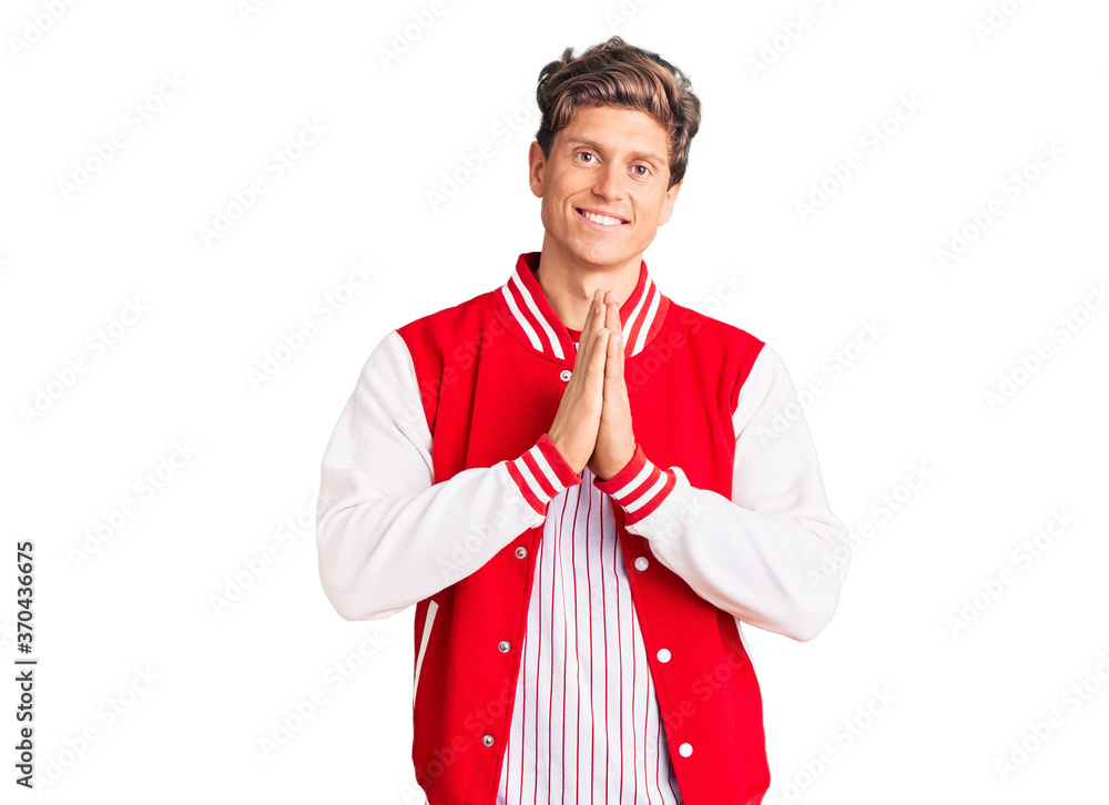 Young handsome man wearing baseball uniform praying with hands together asking for forgiveness smiling confident. Young handsome man wearing baseball uniform praying with hands together asking for forgiveness smiling confident.