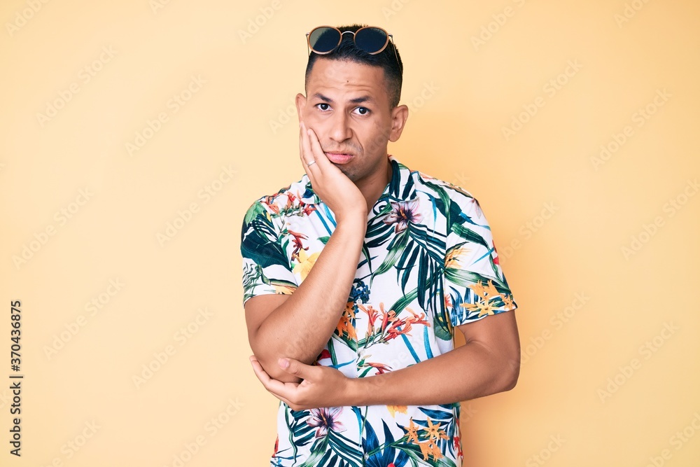 Young handsome latin man wearing summer clothes thinking looking tired and bored with depression problems with crossed arms.