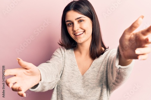 Wallpaper Mural Young beautiful girl wearing casual sweater looking at the camera smiling with open arms for hug. cheerful expression embracing happiness. Torontodigital.ca