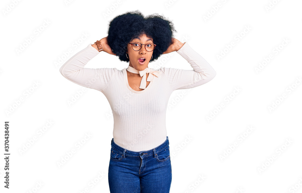 Young african american girl wearing casual clothes and glasses crazy and scared with hands on head, afraid and surprised of shock with open mouth Young african american girl wearing casual clothes and glasses crazy and scared with hands on head, afraid and surprised of shock with open mouth