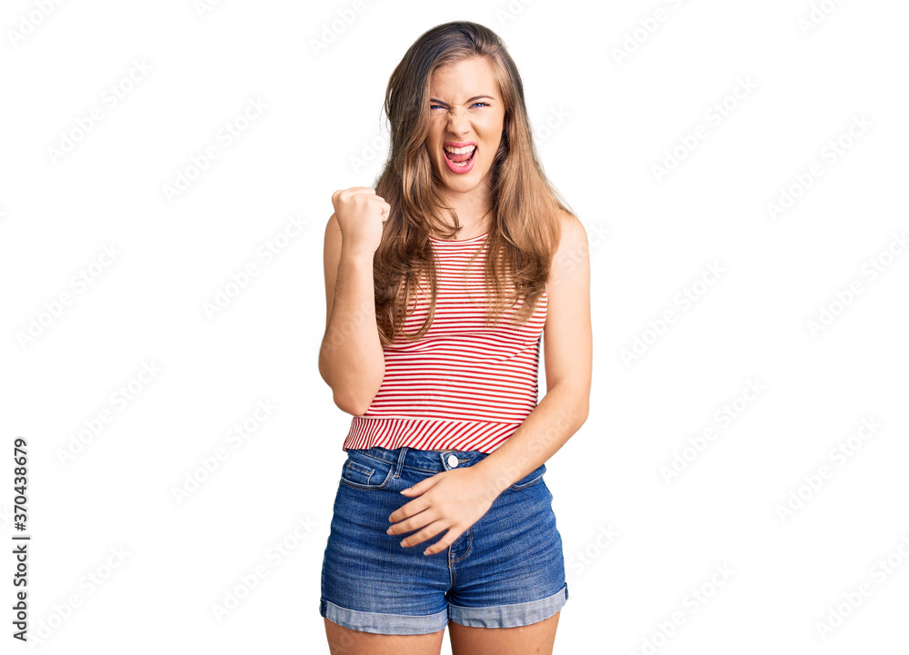 Beautiful caucasian young woman wearing casual clothes angry and mad raising fist frustrated and furious while shouting with anger. rage and aggressive concept. Beautiful caucasian young woman wearing casual clothes angry and mad raising fist frustrated and furious while shouting with anger. rage and aggressive concept.