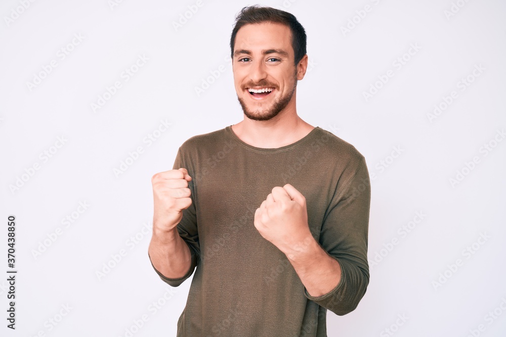 Young handsome man wearing casual clothes very happy and excited doing winner gesture with arms raised, smiling and screaming for success. celebration concept. Young handsome man wearing casual clothes very happy and excited doing winner gesture with arms raised, smiling and screaming for success. celebration concept.