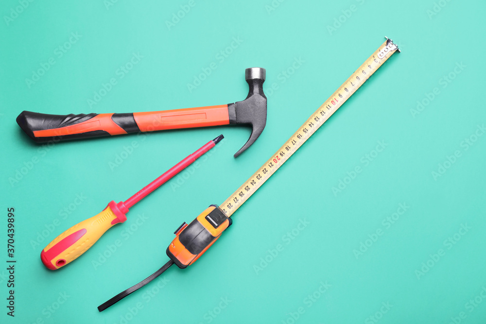 Fototapeta premium Measuring tape with builder's supplies on color background