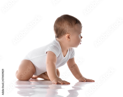 Little baby girl toddler in diaper and white blank body suit crawling on floor and looking up at the corner isolated on white 