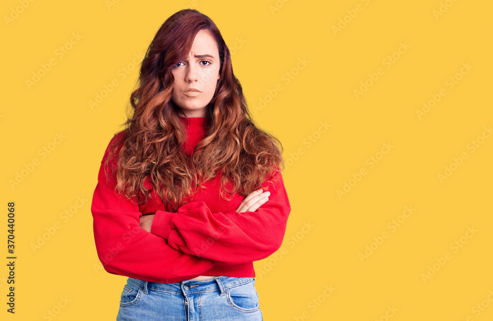 Young beautiful woman wearing casual winter sweater skeptic and nervous, disapproving expression on face with crossed arms. negative person.