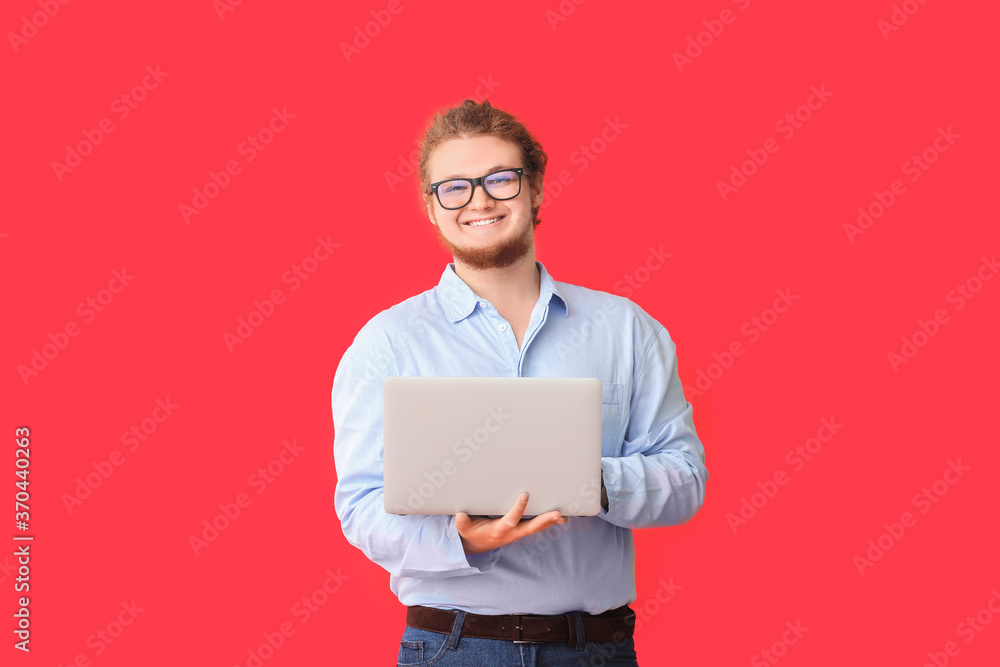Young businessman with laptop on color background Young businessman with laptop on color background