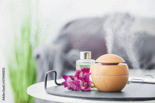 Aroma oil diffuser on table in room photo