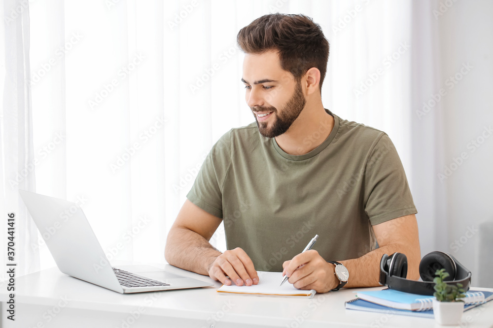 Young man using laptop for online learning at home Young man using laptop for online learning at home