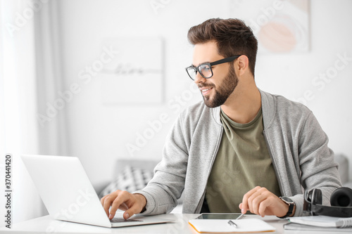 Young man using laptop for online learning at home photo