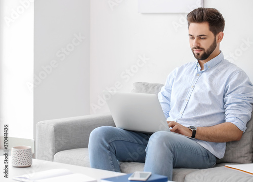 Young man using laptop for ...