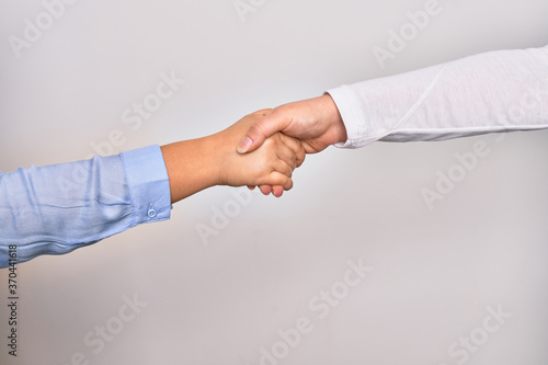 Handshake of two hands of young caucasian businesswomen for agreement over isolated white background