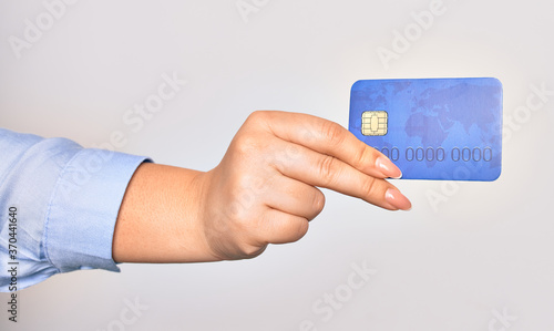 Hand of caucasian young woman holding credit card over isolated white background