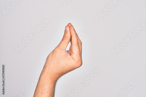 Hand of caucasian young man showing fingers over isolated white background doing Italian gesture with fingers together, communication gesture movement photo