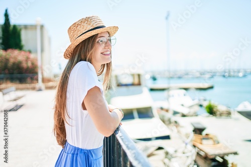 Young blonde woman on vacation smiling happy leaning on balustrade at street of city © Krakenimages.com