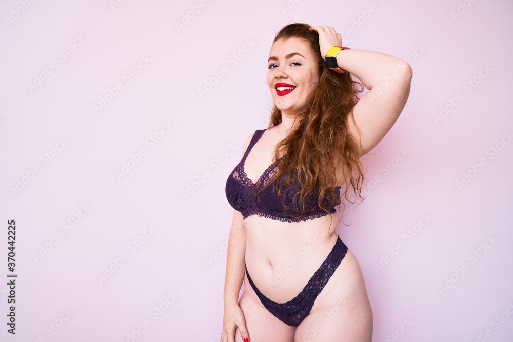 Young plus size redhead woman wearing sexy lingerie smiling happy Standing  with smile on face and hand on hair over isolated pink background Stock  Photo | Adobe Stock