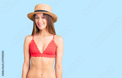 Beautiful brunette young woman wearing bikini with a happy and cool smile on face. lucky person.