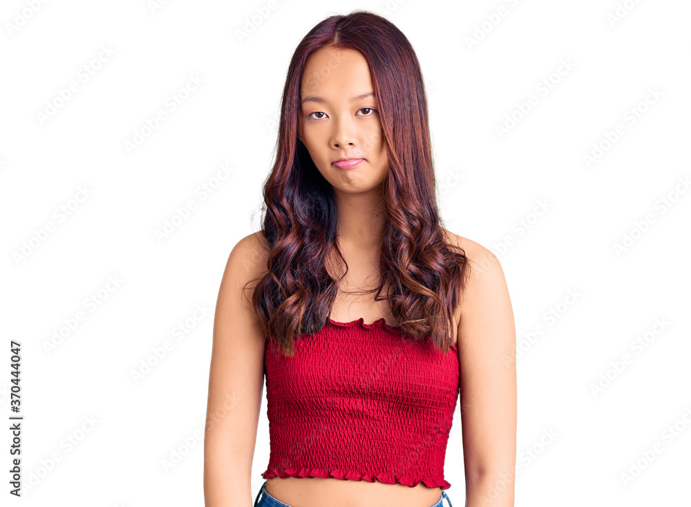 Young beautiful chinese girl wearing casual clothes depressed and worry for distress, crying angry and afraid. sad expression. Young beautiful chinese girl wearing casual clothes depressed and worry for distress, crying angry and afraid. sad expression.