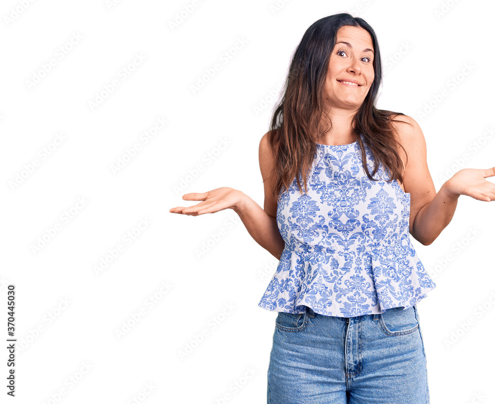 Young beautiful brunette woman wearing casual t-shirt clueless and confused expression with arms and hands raised. doubt concept. Young beautiful brunette woman wearing casual t-shirt clueless and confused expression with arms and hands raised. doubt concept.