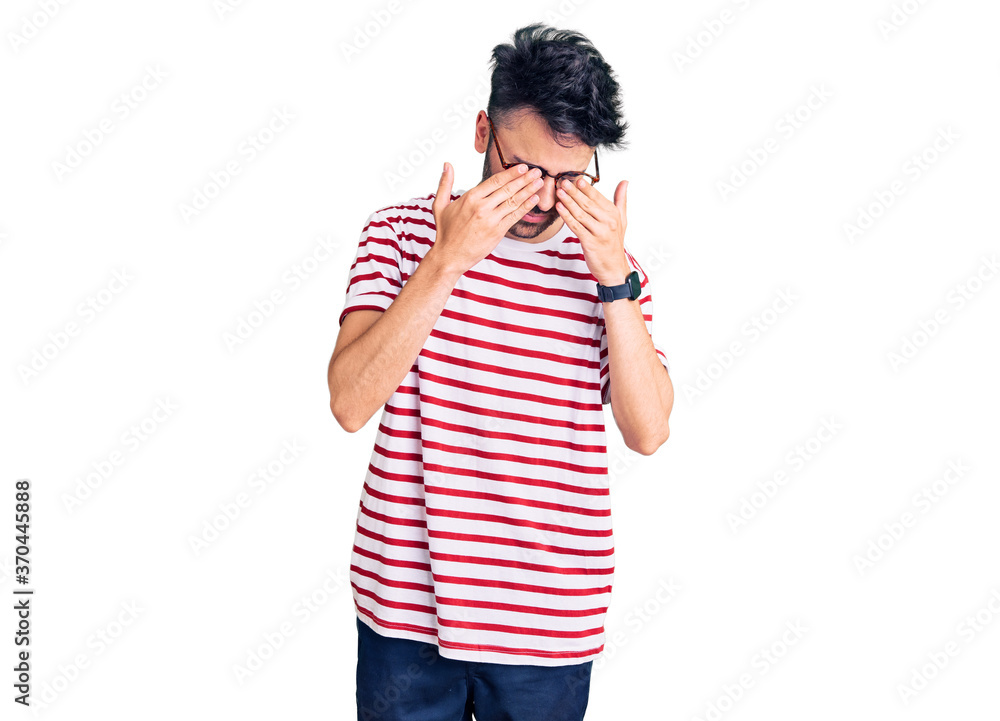 Young hispanic man wearing casual clothes rubbing eyes for fatigue and headache, sleepy and tired expression. vision problem Young hispanic man wearing casual clothes rubbing eyes for fatigue and headache, sleepy and tired expression. vision problem
