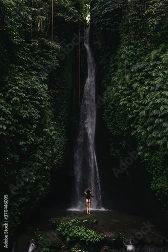 young woman backpacker looking at the waterfall in jungles. Ecotourism concept image travel girl