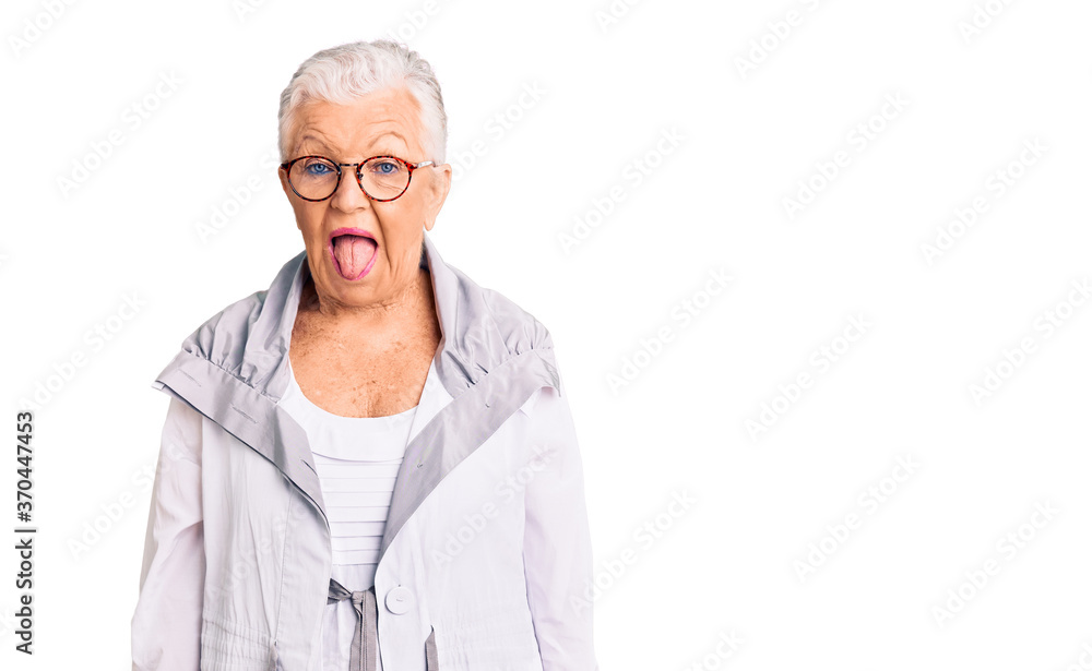 Senior beautiful woman with blue eyes and grey hair wearing casual clothes and glasses sticking tongue out happy with funny expression. emotion concept. Senior beautiful woman with blue eyes and grey hair wearing casual clothes and glasses sticking tongue out happy with funny expression. emotion concept.