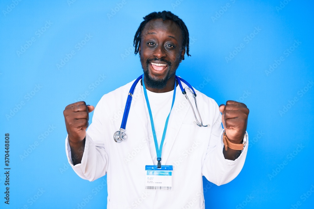 Young african american man with braids wearing doctor stethoscope and id pass screaming proud, celebrating victory and success very excited with raised arms Young african american man with braids wearing doctor stethoscope and id pass screaming proud, celebrating victory and success very excited with raised arms