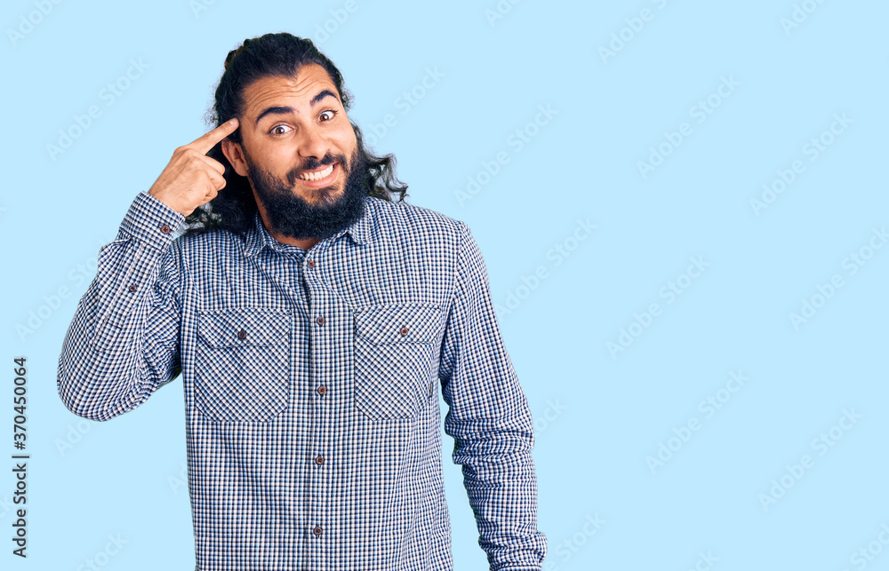Young arab man wearing casual clothes smiling pointing to head with one finger, great idea or thought, good memory Young arab man wearing casual clothes smiling pointing to head with one finger, great idea or thought, good memory