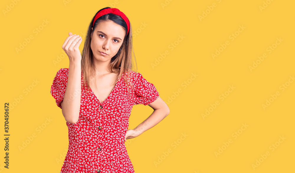 Young beautiful girl wearing dress and diadem doing italian gesture with hand and fingers confident expression Young beautiful girl wearing dress and diadem doing italian gesture with hand and fingers confident expression