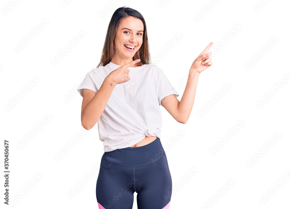 Young beautiful girl wearing casual t shirt smiling and looking at the camera pointing with two hands and fingers to the side. Young beautiful girl wearing casual t shirt smiling and looking at the camera pointing with two hands and fingers to the side.