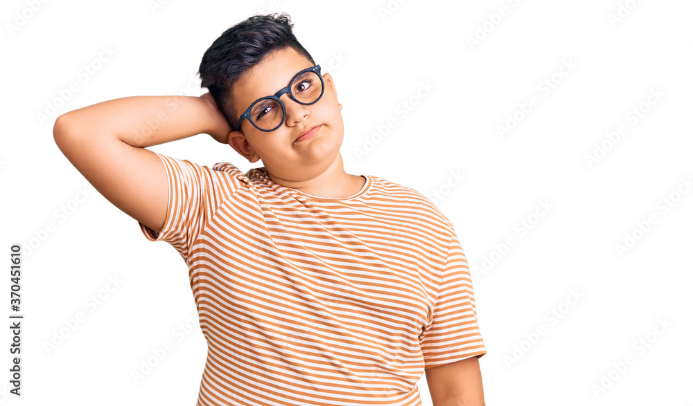 Little boy kid wearing casual clothes and glasses confuse and wondering about question. uncertain with doubt, thinking with hand on head. pensive concept. Little boy kid wearing casual clothes and glasses confuse and wondering about question. uncertain with doubt, thinking with hand on head. pensive concept.