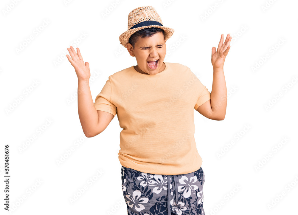 Little boy kid wearing summer hat and hawaiian swimsuit celebrating mad and crazy for success with arms raised and closed eyes screaming excited. winner concept Little boy kid wearing summer hat and hawaiian swimsuit celebrating mad and crazy for success with arms raised and closed eyes screaming excited. winner concept