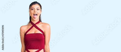 Young beautiful woman wearing casual clothes sticking tongue out happy with funny expression. emotion concept. © Krakenimages.com