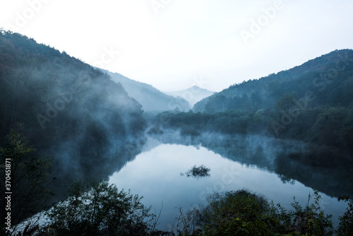 Beautiful autumn scenery, water mist over the lake and sea clouds on the mountain at dawm.