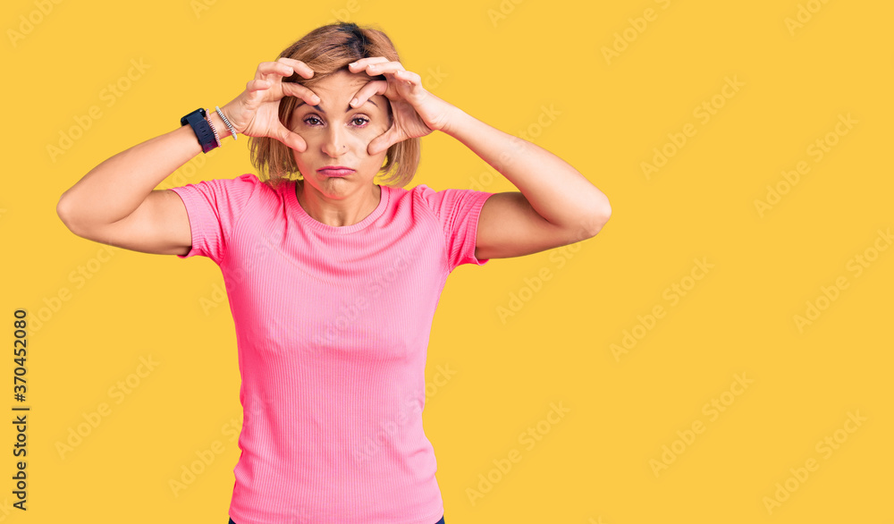 Young blonde woman wearing sportswear trying to open eyes with fingers, sleepy and tired for morning fatigue Young blonde woman wearing sportswear trying to open eyes with fingers, sleepy and tired for morning fatigue