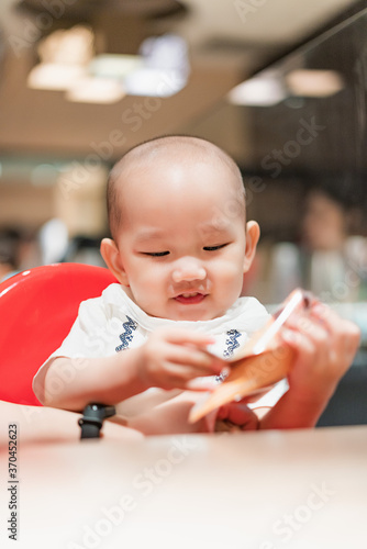 A baby boy in a dining chair in a dining room