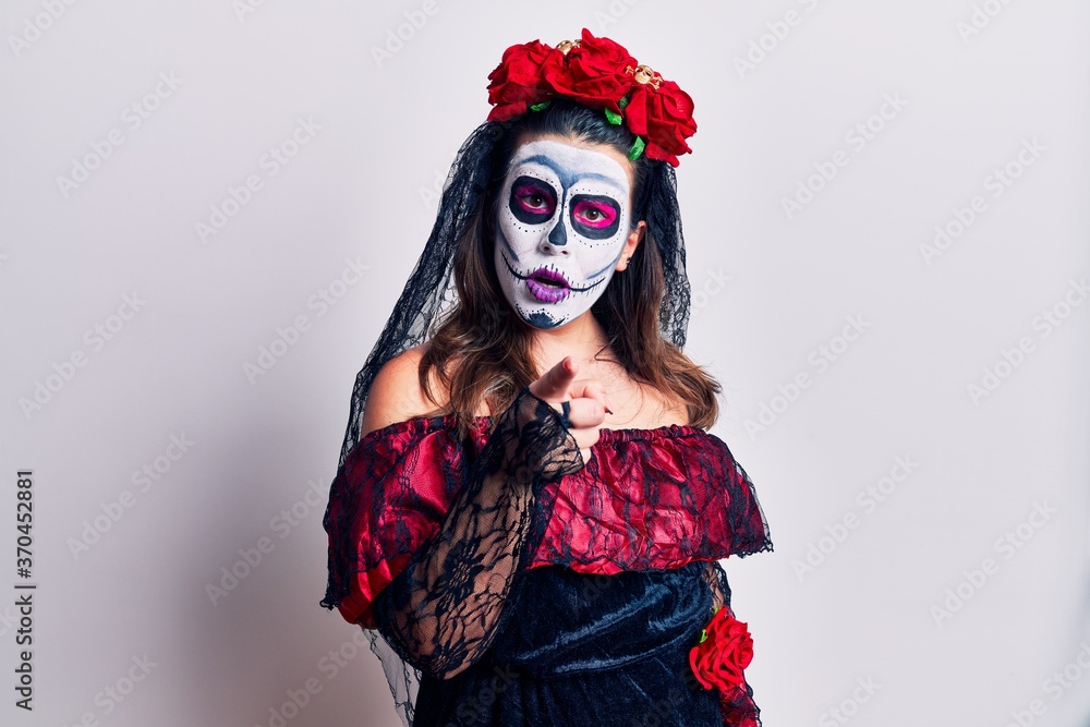 Young woman wearing day of the dead costume over white pointing displeased and frustrated to the camera, angry and furious with you Young woman wearing day of the dead costume over white pointing displeased and frustrated to the camera, angry and furious with you