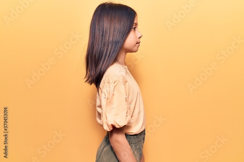 Fototapeta Beautiful child girl wearing casual clothes looking to side, relax profile pose with natural face with confident smile