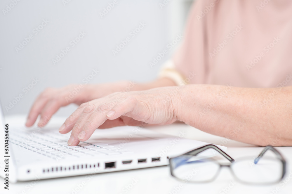 Senior woman works on laptop computer in a office Senior woman works on laptop computer in a office