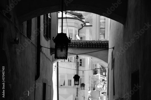 three antique lamps hang in narrow lane in the old town of Bolzano, South Tirol. Monochrome © Chris Peters