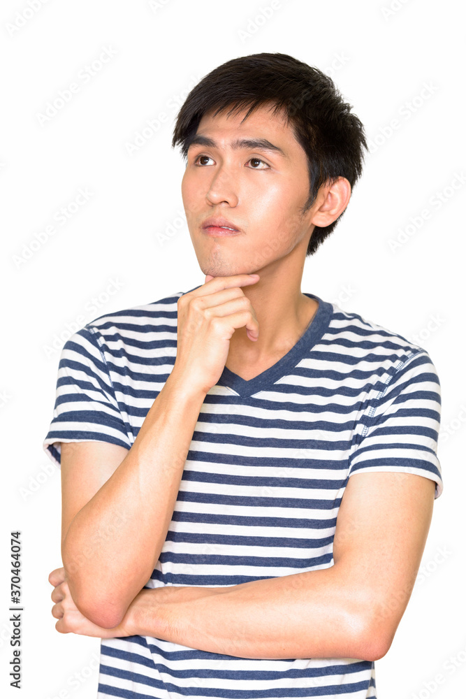 Studio shot of young handsome Asian man thinking against white background Studio shot of young handsome Asian man thinking against white background